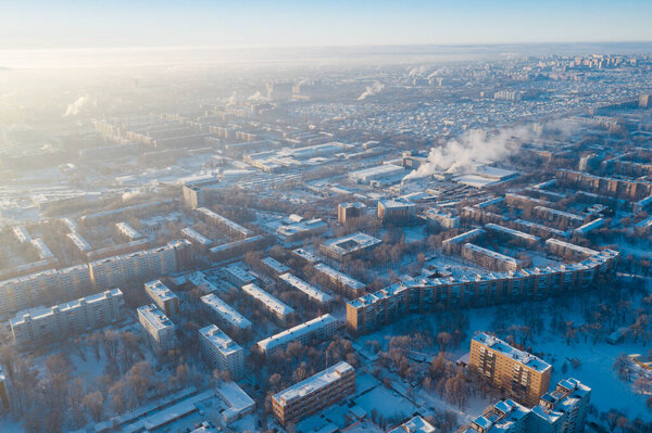 Winter russian city Samara, aerial panorama with many living and commercial building covered by snow