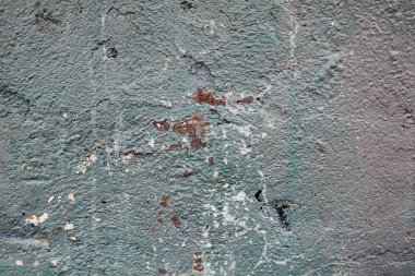 Üstü çimentoyla kaplanmış eski bir tuğla duvar.