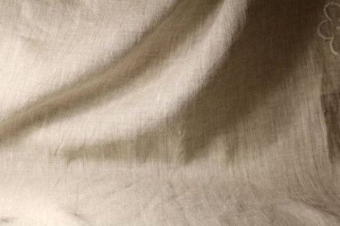 Pürüzsüz bir yüzeyi ve ışıltısı olan boyanmamış kumaş.