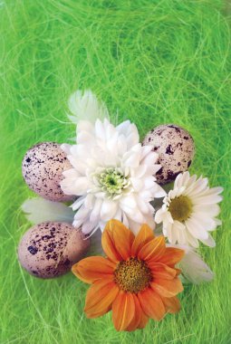 Çiçekli, yumurtalı, yeşil sisal lifli tüylü bir Paskalya natürmortu.