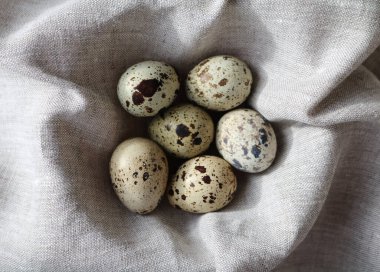 Gri keten kumaştan katlanmış bıldırcın yumurtaları.