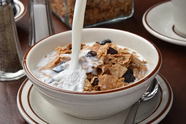 Milch auf Frühstücksflocken gießen — Stockfoto