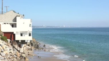 Malibu Sahili 'nde okyanus üzerinde bir ev sallanıyor.