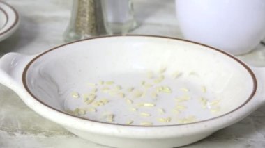 Bir kaseye uzun tahıllı kahverengi pirinç dökülüyor.