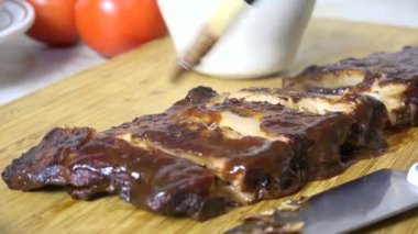 Dilimlenmiş kaburgaların üzerinde barbekü sosu.