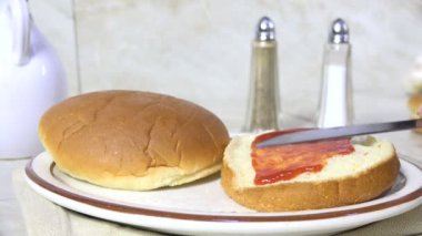 Hamburger ekmeğine ketçap sürüyorum.