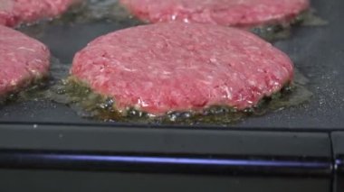 Izgarada cızırdayan bir hamburgerin yakın çekimi