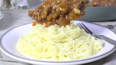 Makarna üzerine et ve spagetti sosu kaşık kaşık.
