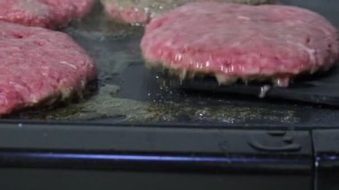 Izgarada bir gurme hamburger çeviriyorum.