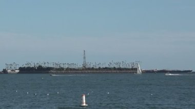 Long Beach limanında Freeman Adası petrol sondaj platformlarının yanından geçen tekneler.
