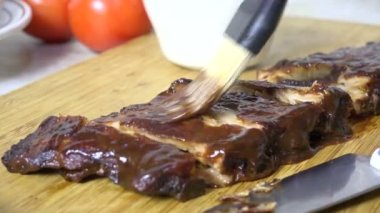 Dilimlenmiş kaburgaların üzerinde barbekü sosu.