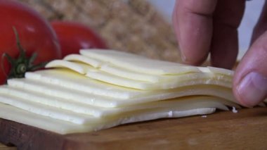 İsviçre peynirinden bir dilim alıp ekmeğin üzerine koy, ağır çekimde.