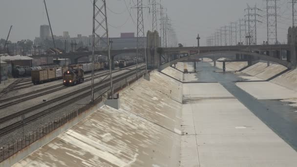 Pociąg Towarowy Zbliża Się Wzdłuż Rzeki Los Angeles Centrum — Wideo stockowe
