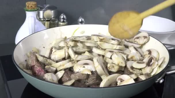 調理された牛肉とスライスされたキノコがフライパンで煮る — ストック動画