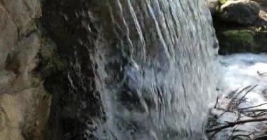 Yavaş çekimde akıntıya çarpan bir şelalenin yakınına.
