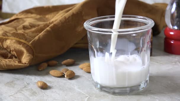 新鮮なアーモンドミルクのグラスを置くスローモーション — ストック動画