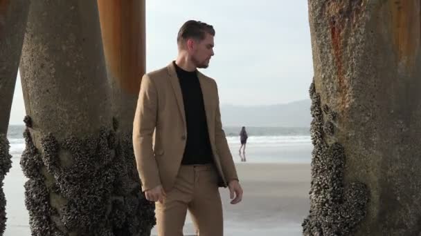 Sexy Mężczyzna Model Garnitur Pozowanie Pod Molo Plaża — Wideo stockowe