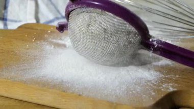 Un dolu bir süzgeç kesme tahtasına yavaş çekimde düşüyor.