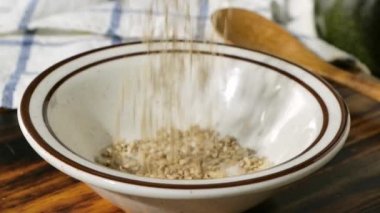 Susam tohumlarını süper yavaş çekimde küçük bir kaseye boşaltıyorlar.