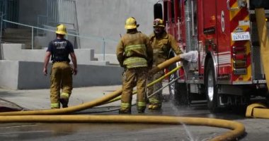 Los Angeles, CA USA - 20 Mart 2021: İtfaiyeciler şehirdeki bir evsizler kampında yangın söndürürken yangın söndürüyorlar