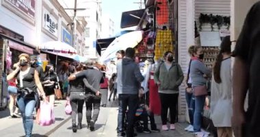 Los Angeles, CA ABD - 2 Mayıs 2021: Los Angeles karantinadan sonra yeniden açılmaya başlarken maskeli kalabalık Santee Alley 'e akın ediyor