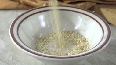 Küçük bir tabağa kinoa tohumları dökülüyor.