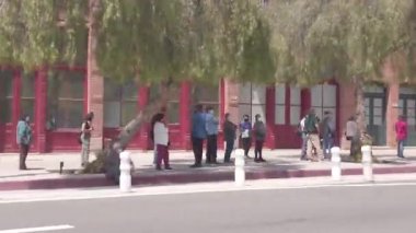 Los Angeles, CA USA - 21 Nisan 2021: İnsanlar Covid-19 aşılarını almak için Los Angeles El Pueblo Plaza 'daki bir aşı merkezinde kuyruğa girdiler