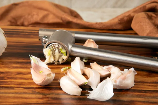 Fresh garlic being pressed from a garlic press