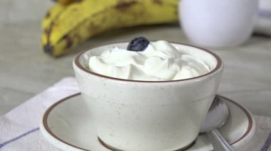 Bir kase yoğurdun üzerine taze yaban mersini döküyorum. 