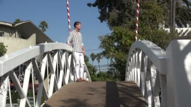 Kırsal bir köprüde manzaraya bakan genç bir erkek turist