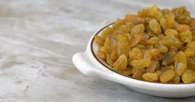 Bir kase altın kuru üzüm mutfak tezgahının üzerinde kayıyor.