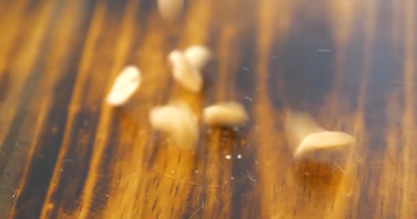 Orzeszki Ziemne Spadające Ciemną Drewnianą Deskę Krojenia Slow Motion — Wideo stockowe