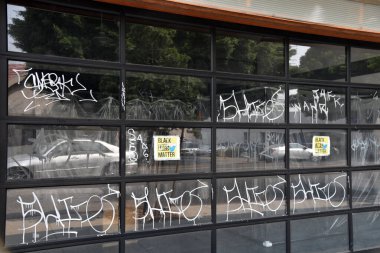 Los Angeles, CA USA - September 13, 2020: Black lives matter signs and graffiti cover windows of a retail business that couldn't reopen after long lockdowns clipart
