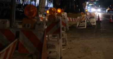 Şehirdeki bir inşaat alanında uyarı levhalarında sarı ışık yanıyor.