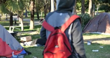 Los Angeles, CA USA - 27 Ocak 2021 MacArthur Park 'taki bir kampta çadırların yanında uyuyan evsiz bir adam 