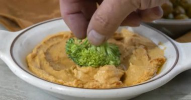 Brokoli çiçeğini taze humusa bandırıyorum.