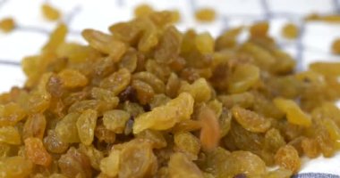 Taze altın kuru üzümler yavaş çekimde mutfak havlusuna dökülüyor.