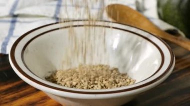 Susam tohumlarını küçük bir kaseye dökerek.