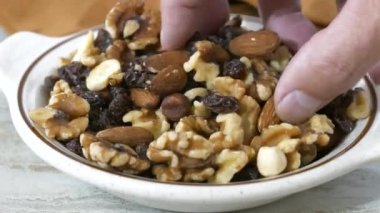 Bir avuç sağlıklı gurme yiyorum fındık ve kuru üzümle karıştırıyorum.
