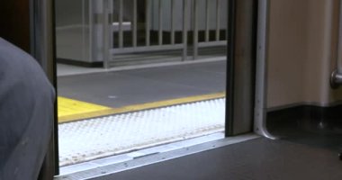 Bir metronun kapısı ağır çekimde kapanıyor.