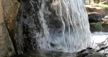 Kayaların üzerinden akan bir şelalenin çekimini yakından çek