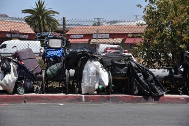 Los Angeles, CA USA - 30 Haziran 2021: Los Angeles 'ta evsiz insanların sahip olduğu eşyalar ve tekerlekli sandalyeler kaldırımda kuyruk oluşturuyor