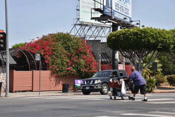 ロサンゼルス Usa 2021年7月12日 路上をショッピングカートで横断するホームレスの男 — ストック写真