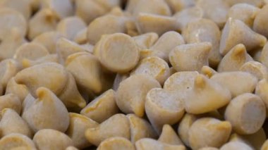 Karamela parçaları yavaş çekimde ahşap bir masaya düşüyor.