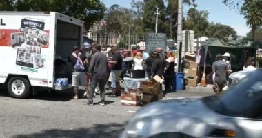Los Angeles, CA USA - 3 Temmuz 2021: Bağımsızlık Günü 'nde Gaziler Hastanesi' nin dışındaki evsizler için yiyecek yükleyen insanlar