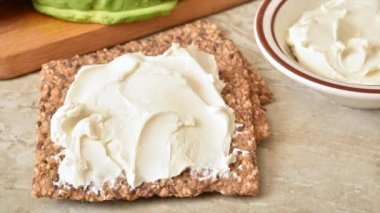 Glütensiz çıtır kraker üzerine avokado ve krem peynirli tost yapmak hareketli animasyonu durdurur.
