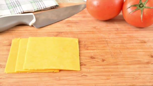 カッティングボードのストップモーションアニメーションに登場するチェダーチーズのスライス — ストック動画