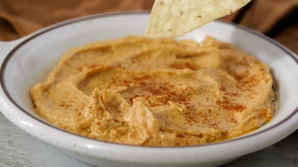 Mencelupkan Jagung Tortilla Chip Dalam Semangkuk Hummus — Stok Video