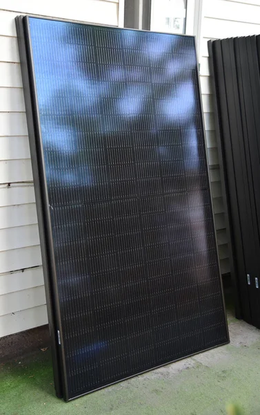 屋根の上に設置されるのを待っている家に向かって休んでいる太陽電池パネル — ストック写真