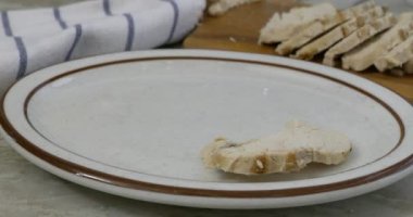 Kızarmış tavuk göğsü dilimleri bir tabağa yakın servis ediliyor.